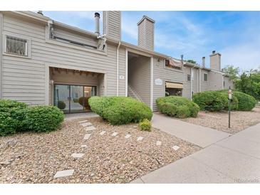 Inviting condo exterior featuring manicured landscaping and a charming stone pathway at 3600 S Pierce St # 5-101, Denver, CO 80235