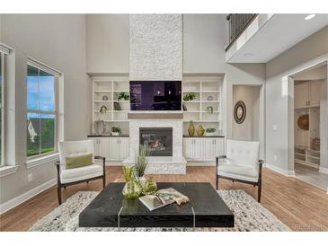 Bright living room featuring a fireplace, built-in shelving, and elegant decor for a cozy yet stylish space at 11821 Discovery Ln, Parker, CO 80138