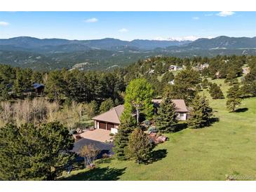 Expansive home with a three-car garage is surrounded by mature trees and offers stunning mountain views at 1621 Baneberry Ln, Golden, CO 80401