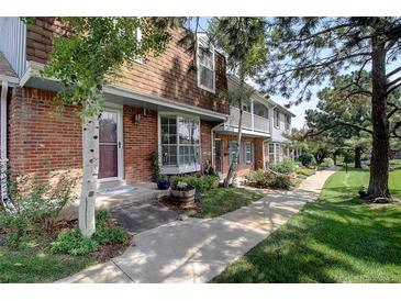 Charming brick townhome with landscaped front yard and inviting entryway, showcasing curb appeal at 7396 S Knolls Way, Centennial, CO 80122