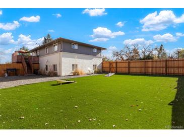 Expansive backyard features lush artificial turf, creating a perfect low-maintenance outdoor living space at 6163 W 76Th Ave, Arvada, CO 80003