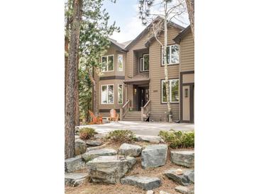 Inviting two-story home featuring a rock garden, covered entryway, and outdoor seating at 2253 Augusta Dr, Evergreen, CO 80439