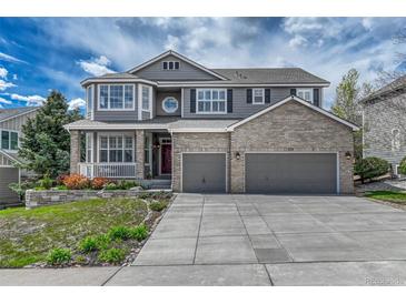 Attractive two-story home featuring brick and siding accents, a two-car garage, and a landscaped front yard at 570 Stonemont Dr, Castle Pines, CO 80108