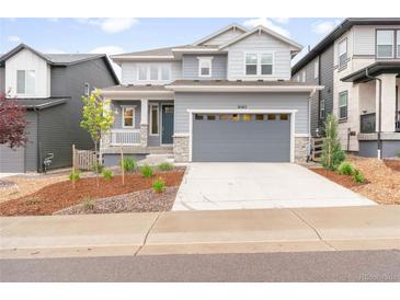 Charming two-story home with a gray exterior, a two-car garage, and a well-maintained front yard at 8582 Cheraw St, Littleton, CO 80125