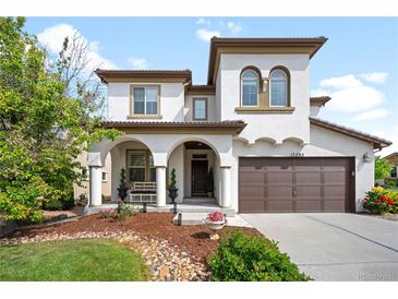 Stunning two-story home featuring a covered front porch, a two-car garage, and manicured landscaping at 15205 W Baker Ave, Lakewood, CO 80228
