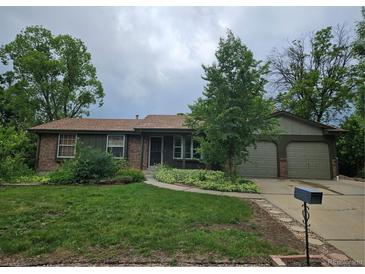Charming ranch-style home featuring mature trees, brick accents, and a well-manicured lawn at 912 E 6Th Ave, Broomfield, CO 80020