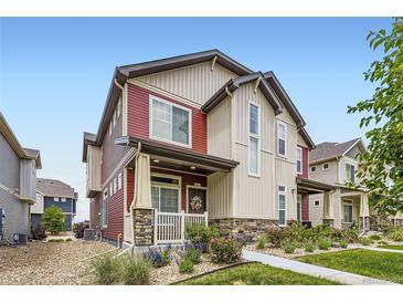 Charming two-story home featuring a landscaped yard and welcoming front porch at 17855 E 103Rd Ave, Commerce City, CO 80022