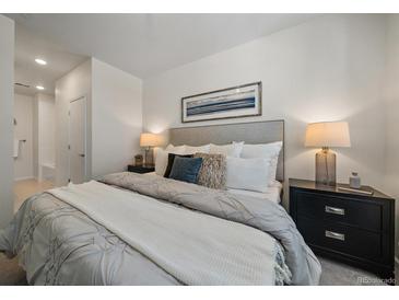 Comfortable bedroom featuring a neutral palette, soft bedding, and elegant lamps on dark end tables at 1841 S Dunkirk St # 203, Aurora, CO 80017
