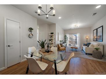 Bright and airy living room and dining area with modern furnishings and hardwood floors at 1841 S Dunkirk St # 203, Aurora, CO 80017