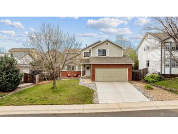 Charming two-story home featuring a well-maintained front yard and attached two-car garage at 5174 S Ukraine St, Aurora, CO 80015