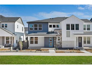 Beautiful two-story home with blue accents, stone trim, and manicured landscaping at 8894 Yellowcress St, Littleton, CO 80125