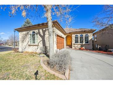Charming single-story home showcasing a well-manicured yard, attached garage, and inviting yellow front door at 13901 E Saratoga Pl, Aurora, CO 80015