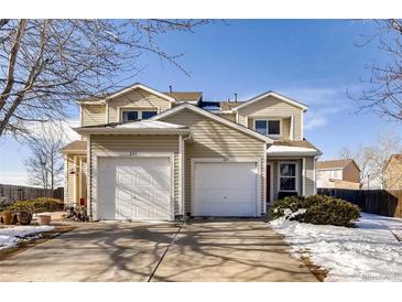 Tan two-story home with attached garage and snow-covered landscaping at 269 Ponderosa Pl, Fort Lupton, CO 80621