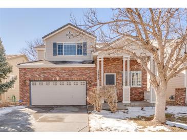 Charming two-story brick home featuring a covered front porch and attached two-car garage at 13973 Cook St, Thornton, CO 80602