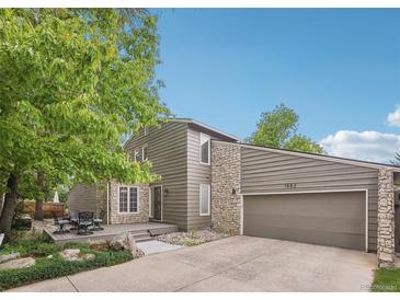 Two-story home with a deck, two-car garage and a combination of stone and wood siding at 1582 W Briarwood Ave, Littleton, CO 80120