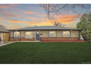 Charming ranch-style home featuring a brick facade, well-maintained lawn, and inviting front entrance with ample natural light at 1244 Peoria St, Aurora, CO 80011