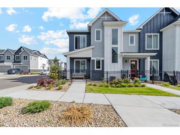 Charming two-story home with a well-maintained lawn, landscaped with plants, and a black metal fence at 1954 S Poplar Ct, Denver, CO 80224