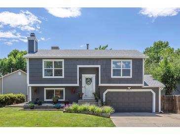 Charming two-story home with a well-maintained lawn, landscaped flower beds, and a gray exterior paint at 3965 S Fundy Cir, Aurora, CO 80013