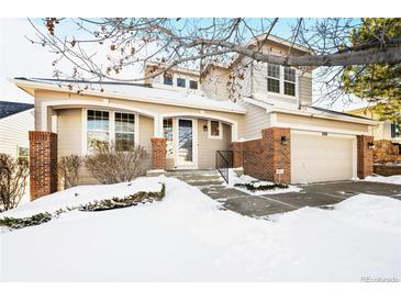 Charming two-story home featuring a welcoming front porch and attached two-car garage at 958 Bramblewood Dr, Castle Pines, CO 80108