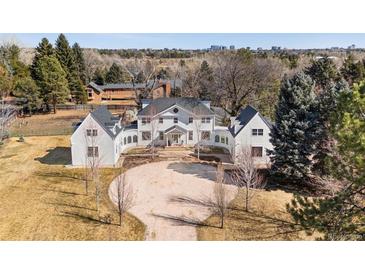 Stunning aerial view of a white home with a circular driveway and lush landscaping at 1 Random Rd, Englewood, CO 80113