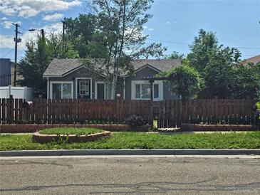 Charming cottage-style home with a well-maintained front yard, complemented by a quaint fence and lush greenery at 4368 Benton St, Denver, CO 80212