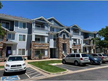 Three-story condo building features stone accents, blue siding, multiple balconies and convenient parking at 5255 Memphis St # 712, Denver, CO 80239
