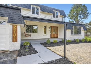 Charming two-story home with a front porch swing and a well-manicured lawn at 2101 Champlain Dr, Boulder, CO 80301