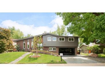 Charming home featuring brick and gray siding, lush landscaping, and a welcoming open carport at 10000 E Ohio Ave, Denver, CO 80247