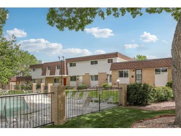 Exterior view of a multi-Gathering home with manicured lawns and a black metal fence surrounding a pool area at 12885 W Alameda Dr, Lakewood, CO 80228