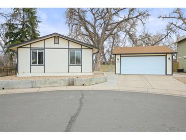 Quaint single-Gathering home with detached garage, cream-colored exterior, and large trees at 9340 Pierce St, Westminster, CO 80021