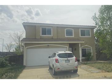 Charming stucco two-story home with a tile roof, attached garage, and well-maintained front yard at 3811 Lisbon Ct, Denver, CO 80249