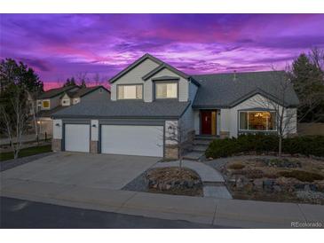 Charming two-story home with a three-car garage, manicured landscaping, and a cozy front porch at twilight at 4530 Ridgewood Ct, Castle Rock, CO 80109