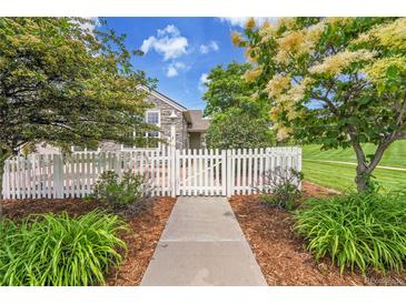 Charming home featuring a white picket fence, beautiful landscaping, and a welcoming entrance at 11268 Grove St # I, Westminster, CO 80031