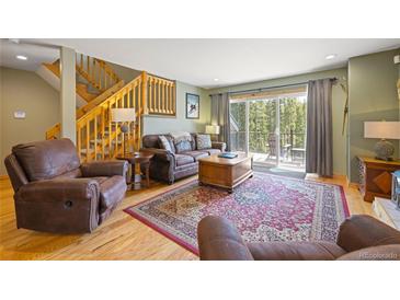 Inviting living room with wood floors, leather furniture, and a walk out to a deck at 100 River Park Dr # A, Breckenridge, CO 80424