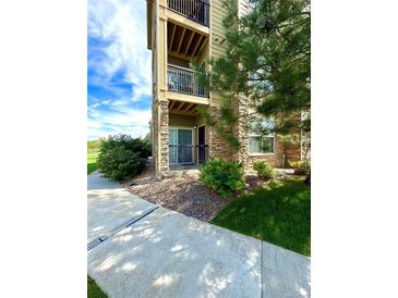 Exterior view of condo building showcasing landscaping and walkway at 17443 Nature Walk Trail # 102, Parker, CO 80134