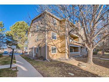 View of a three-story condo building with a mix of stone and wood siding on a sunny day at 1074 S Dearborn St # 108, Aurora, CO 80012