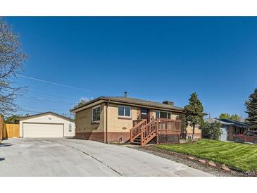 Charming single-story brick home with a well-maintained front yard, wooden porch, and detached garage with a driveway at 3871 Moore St, Wheat Ridge, CO 80033
