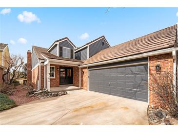 Charming home featuring a two-car garage, brick accents, and a well-maintained front yard at 7079 S Locust Pl, Centennial, CO 80112