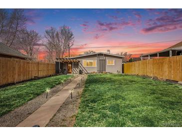 Charming home with a well-maintained front yard, walkway, and delightful sunset backdrop at 4827 Meade St, Denver, CO 80221