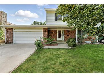 Charming brick home featuring an attached garage and a well-manicured front yard at 1341 S Blackhawk Way, Aurora, CO 80012
