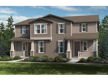 Charming townhome featuring neutral siding, decorative shutters, covered porches, and manicured landscaping at 28640 E 6Th Pl, Watkins, CO 80137