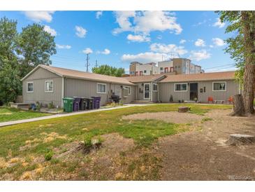 Charming single-story home with a well-maintained lawn and lush landscaping on a sunny day at 1217 Osceola St, Denver, CO 80204