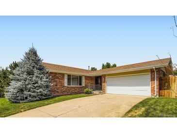 Brick home featuring an attached two-car garage, a well-manicured lawn, and mature trees at 6212 S Ash W Cir, Centennial, CO 80121