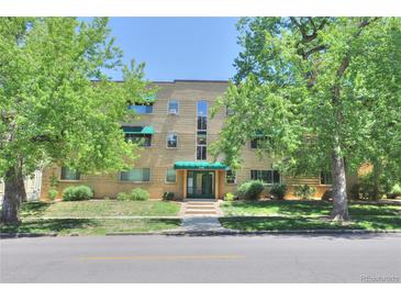 Charming multi-story brick apartment building featuring manicured landscaping and mature trees at 2100 N Franklin St # 8, Denver, CO 80205