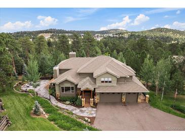 Stunning exterior view of home, nestled in a wooded area with an attached two-car garage at 1456 Shavano Ct, Evergreen, CO 80439