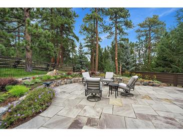 Outdoor patio with comfortable seating, mature trees and beautiful landscape, great for relaxing or entertaining at 1456 Shavano Ct, Evergreen, CO 80439