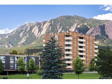 Scenic view of a brick apartment building nestled beneath a majestic mountain range, offering a serene living environment at 850 20Th St # 203, Boulder, CO 80302