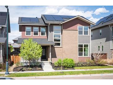 Beautiful two-story home featuring solar panels, landscaping, and a welcoming front entrance at 9007 E 60Th Ave, Denver, CO 80238
