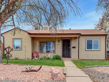Charming home with a well-maintained front yard, inviting walkway, and cozy porch chairs at 675 S Quivas St, Denver, CO 80223