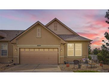 Two-story house featuring a neutral-toned exterior, a two-car garage, and well-maintained landscaping at 6694 S Rome St, Aurora, CO 80016